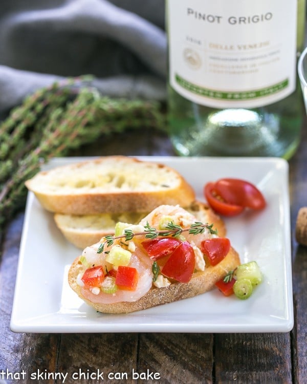 Greek Shrimp Crostini | Garlic toasts topped with shrimp, feta, tomatoes and more!