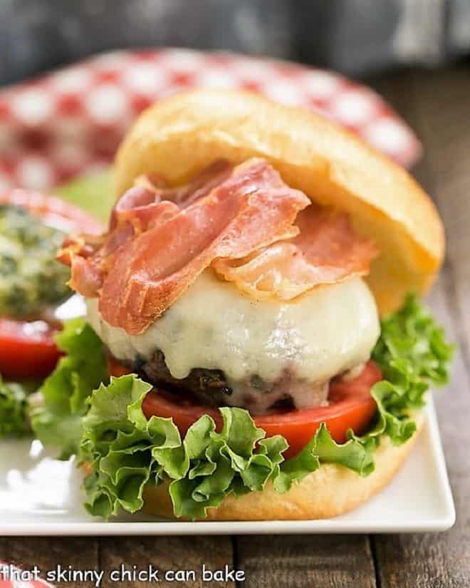 Close up view of Italian Pesto Burger with toppings on a square plate