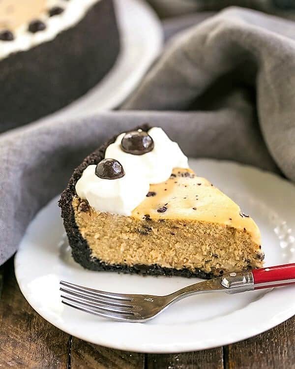 A slice of Mocha Cheesecake with Chocolate Chips on a white dessert plate