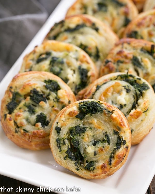 Spinach Feta Pinwheels on a white serving tray.
