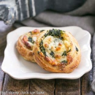 Two Feta and Spinach pinwheets on a square white plate