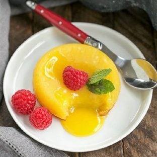 White Chocolate Molten Lava Cakes on a white plate with a red handled spoon