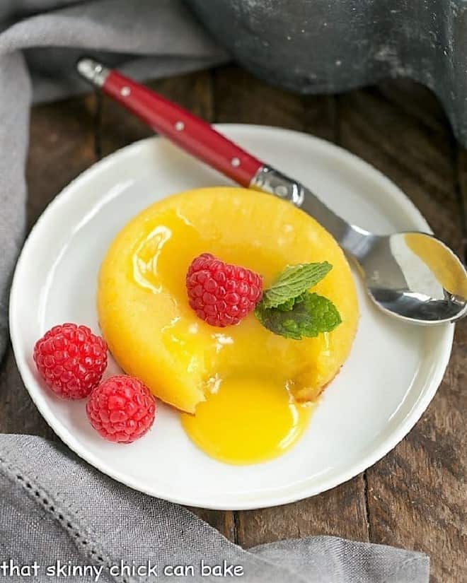 White Chocolate Molten Lava Cakes on a white plate with a red handled spoon.