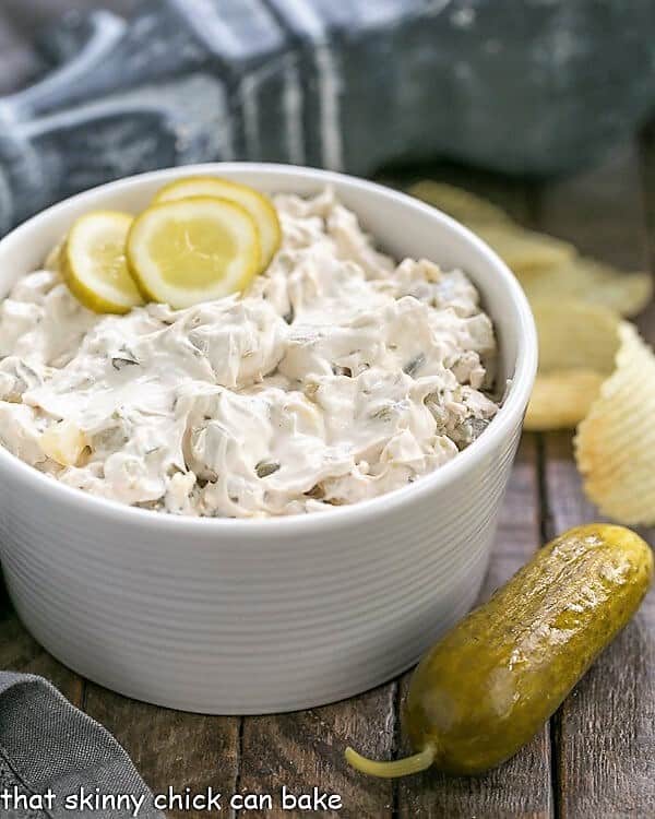 Easy Dill Pickle Dip in a serving bowl with a pickle and ruffled chips