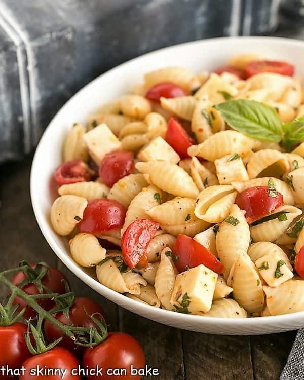 Tomato Basil Pasta Salad with Mozzarella & Fontina in a white ceramic serving bowl