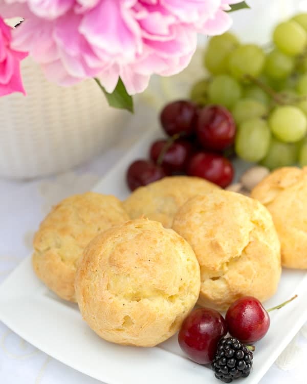 Triple Cheese Gougeres on a white tray with fruit.