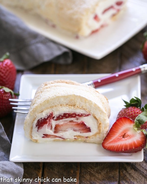 Strawberry Filled Meringue Roulade slice on a white dessert plate