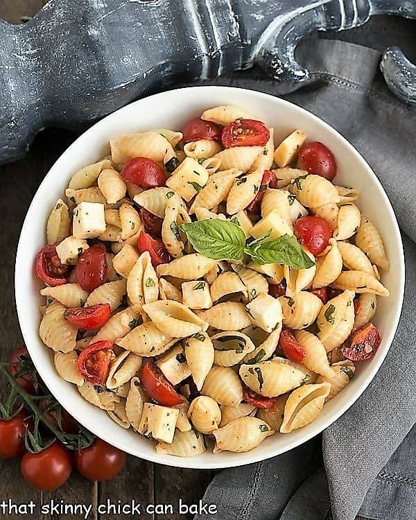 Overhead view of Tomato Basil Pasta Salad with Mozzarella & Fontina in a white serving bowl.