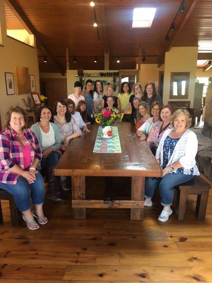 A group of people sitting at a table at the PIoneer Woman\'s studio.