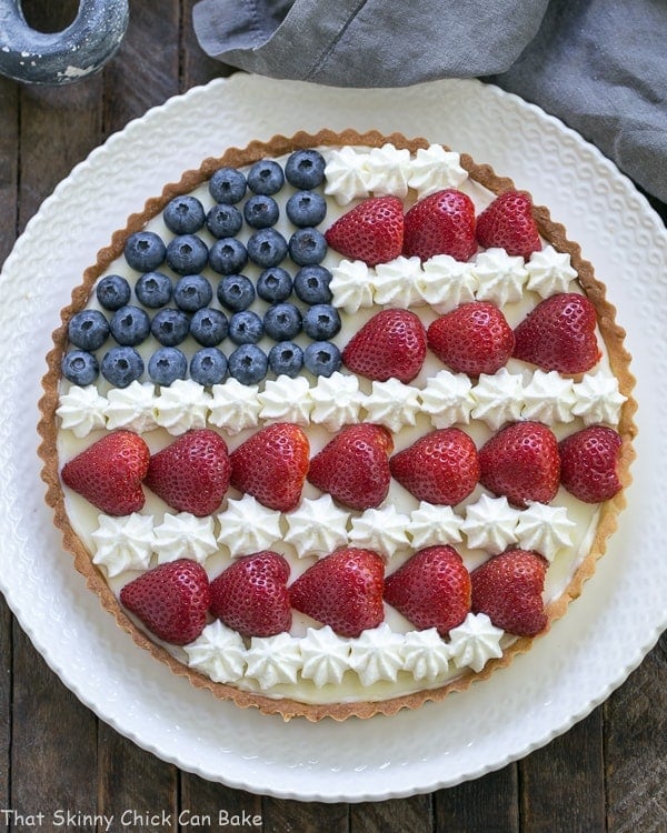 Overhead view of an American Flag Fruit Tart on white serving plate.