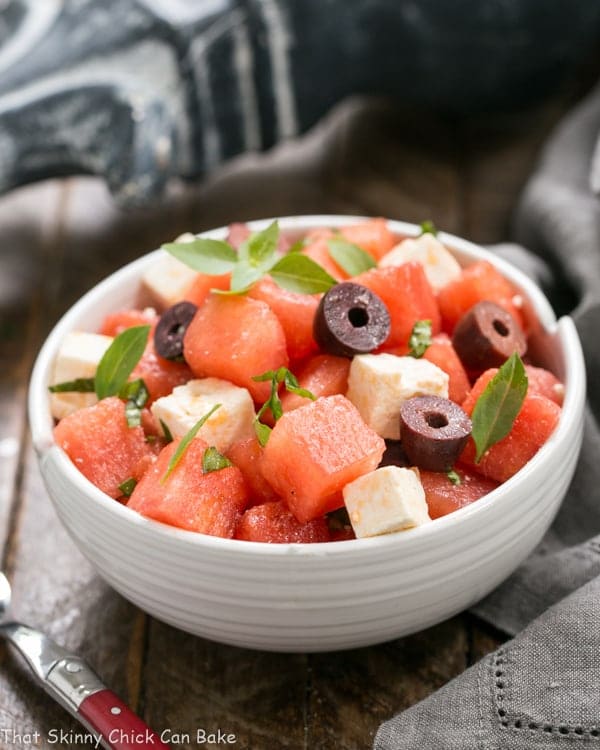 Watermelon Feta Basil Salad with Balsamic Vinaigrette in a white ceramic bowl with a red handled fork