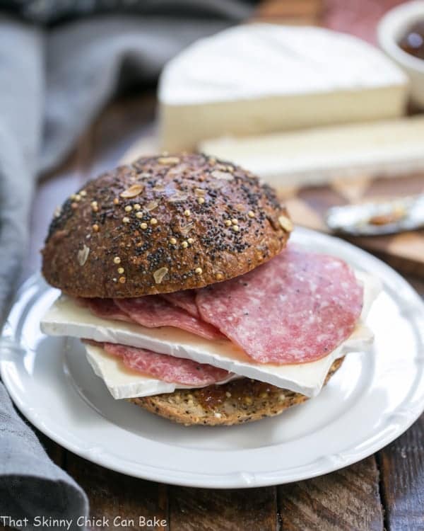 Close view of a Brie Jam and Salami Sandwich on a white plate.