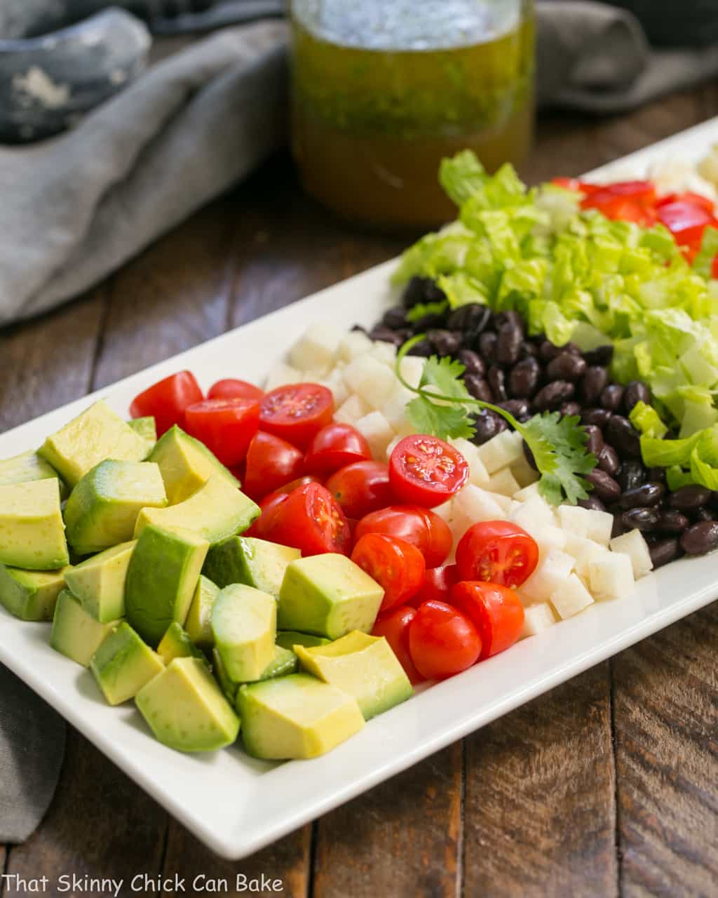 Mexican Chopped Salad with Cilantro Vinaigrette ingredients on a white ceramic tray.