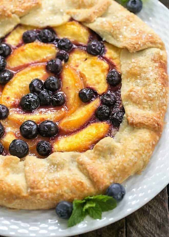 Close view of a Peach Blueberry Galette with a blueberry and mint garnish.