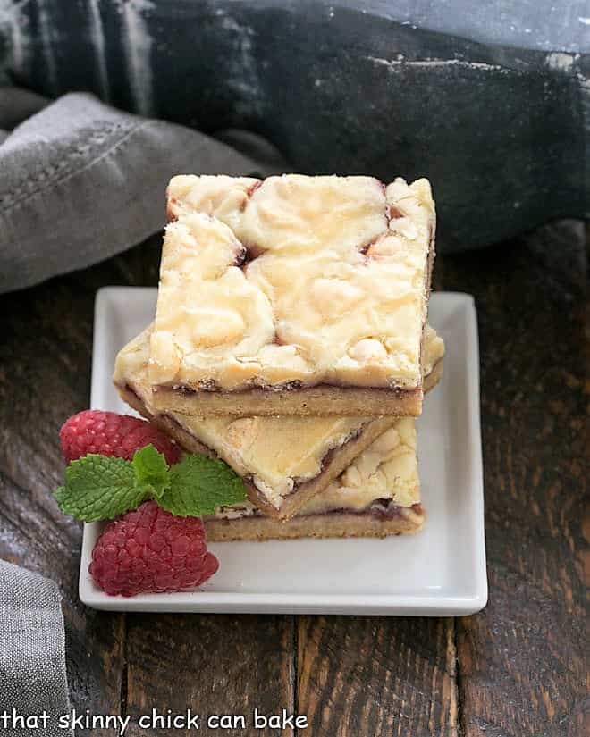 A stack of 3 White Chocolate Raspberry Bars on a small white ceramic plate