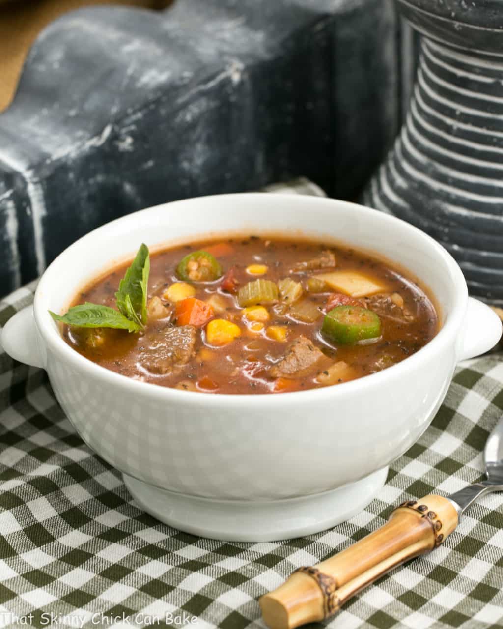 Vegetable Beef Soup in a white bowl on a checkered napkin.