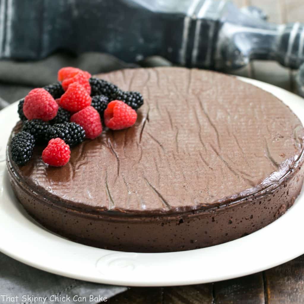 Flourless Cake Chocolate from Princeville Hotel on a white serving plate garnished with fresh berries.