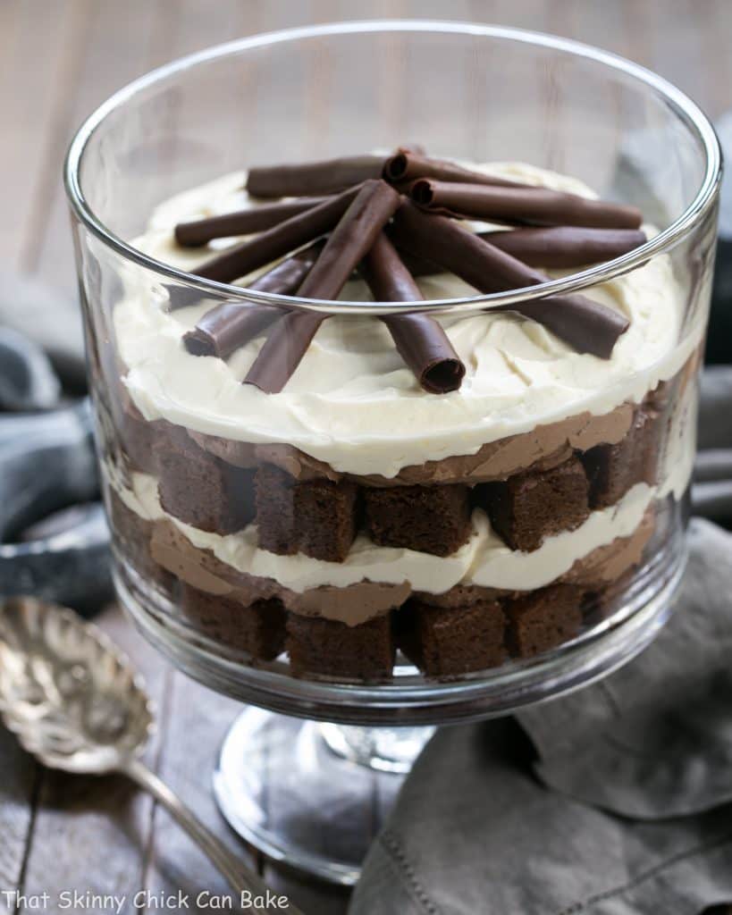 Fudgy Brownie Trifle with Chocolate Mousse in a glass trifle dish with a silver serving spoon