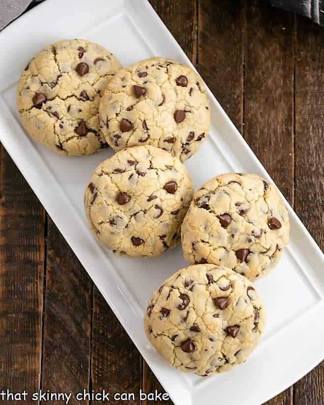 overhead view of big chocolate chip cookies on a white tray.