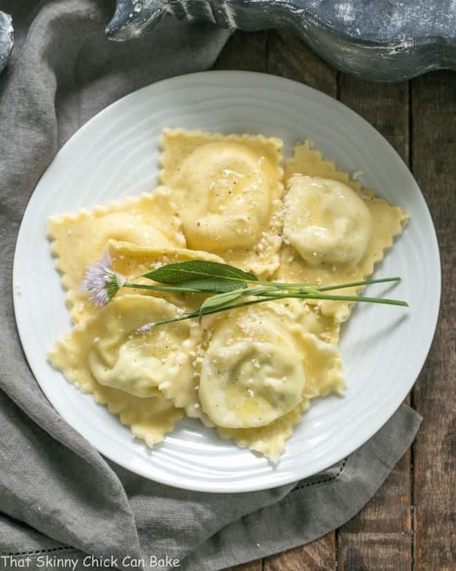 Overhead view of Mozzarella, Basil, Parmigiano-Reggiano Ravioli with Butter Sage Sauce on a white dinner plate