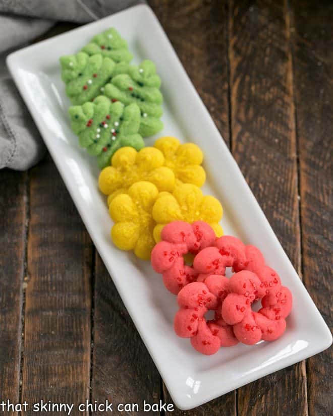 Colorfbuttery spritz cookies on a white ceramic tray