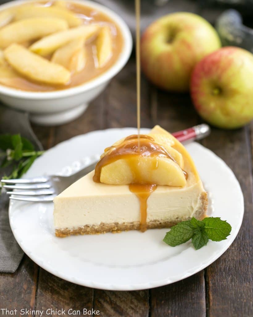 Caramel pouring over a slice of Easy Sour Cream Cheesecake with Caramel Apples