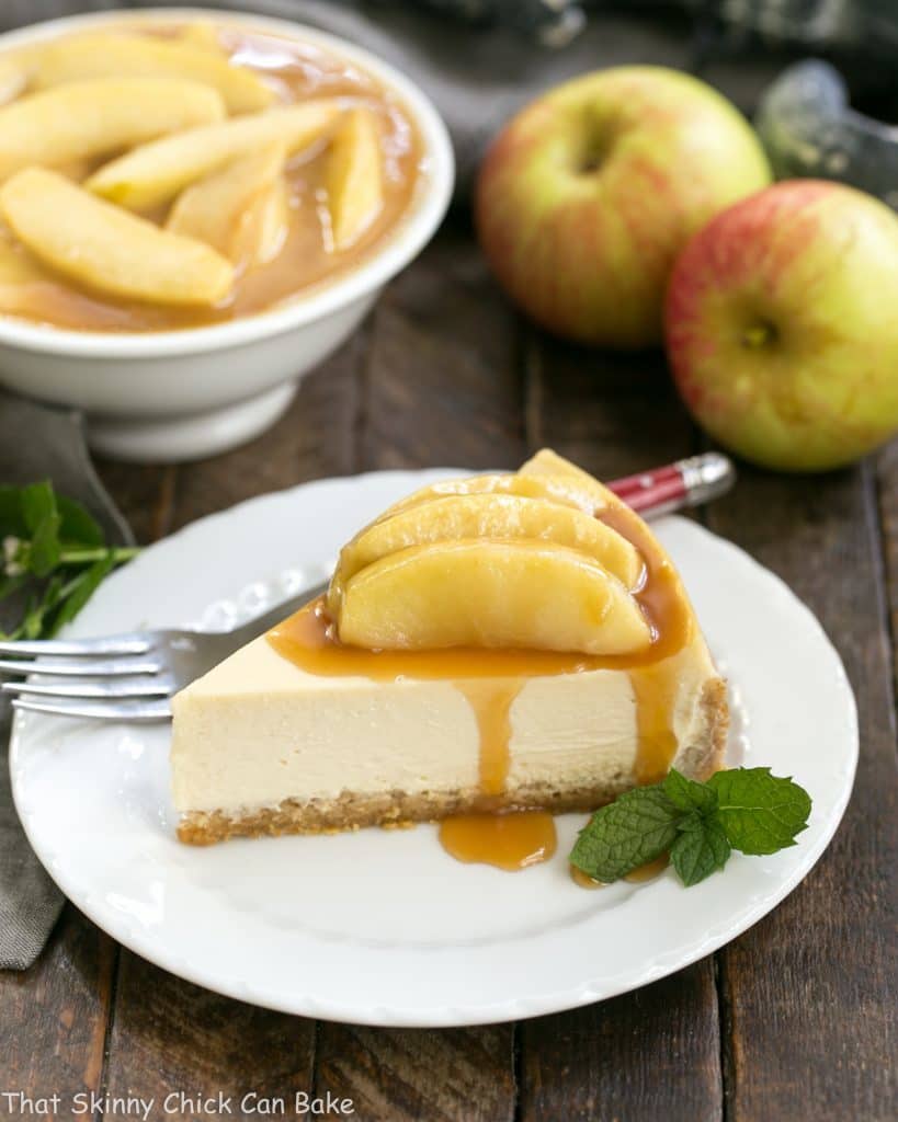Slice of Easy Sour Cream Cheesecake with Caramel Apples on a white dessert plate