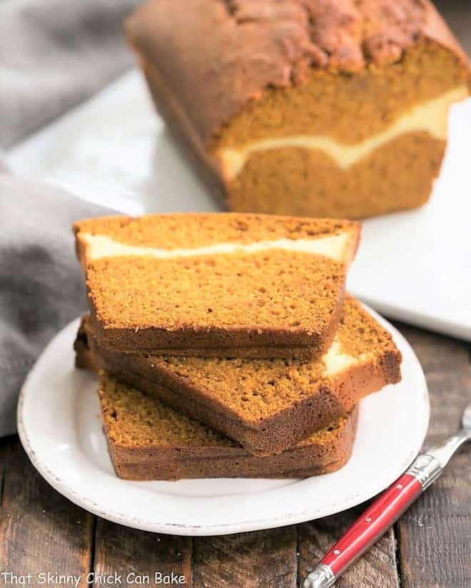 Cream Cheese Filled Pumpkin Bread A moist, delicious pumpkin loaf with a ribbon of cream cheese in the middle! Cream Cheese Filled Pumpkin Bread slices stacked on a white dessert plate.