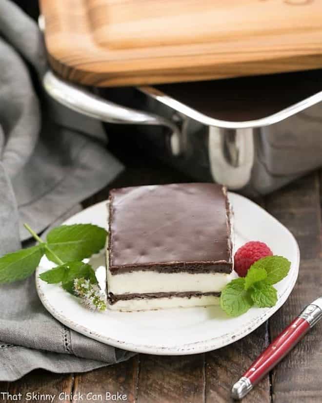 No Bake Chocolate Lasagna slice on a white plate with a mint and a fresh raspberry