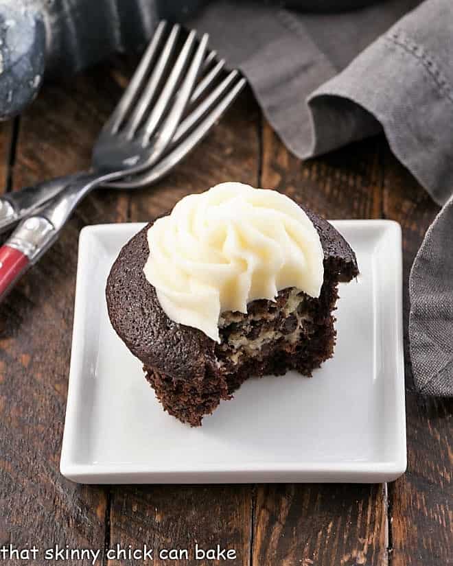 One black bottom cupcake with a forkful removed to reveal the cream cheese filling.