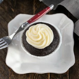 Overhead view of a blackbottom cupcake on a square white plate with a red handled fork