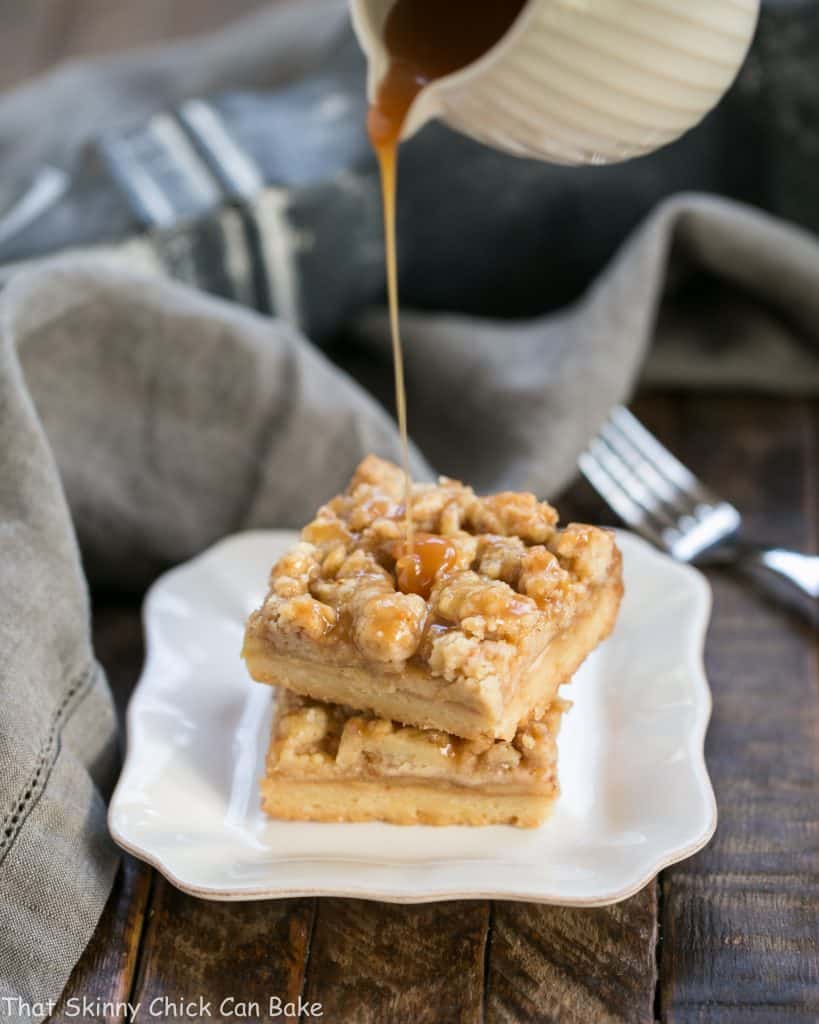 A stream of caramel pouring over a stack of Caramel Apple Pie Bars.
