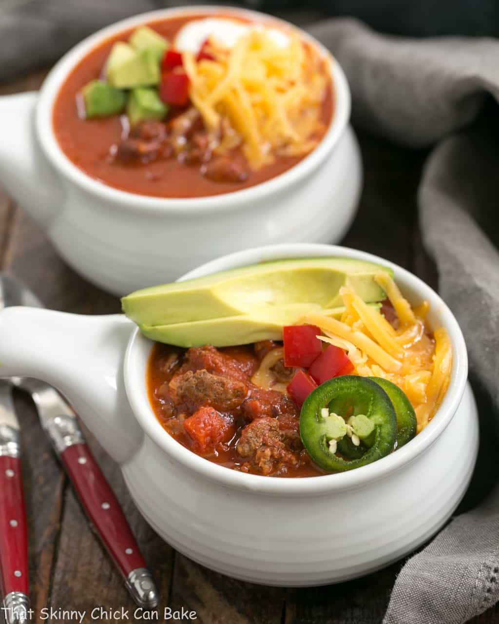 2 bowls of Easy Black Bean Chili garnished with cheese and avocados.