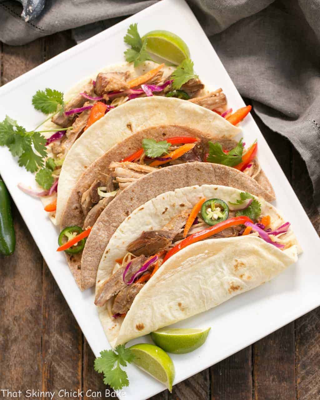Slow Cooker Asian Pork Tacos with Cabbage Slaw on a white platter.