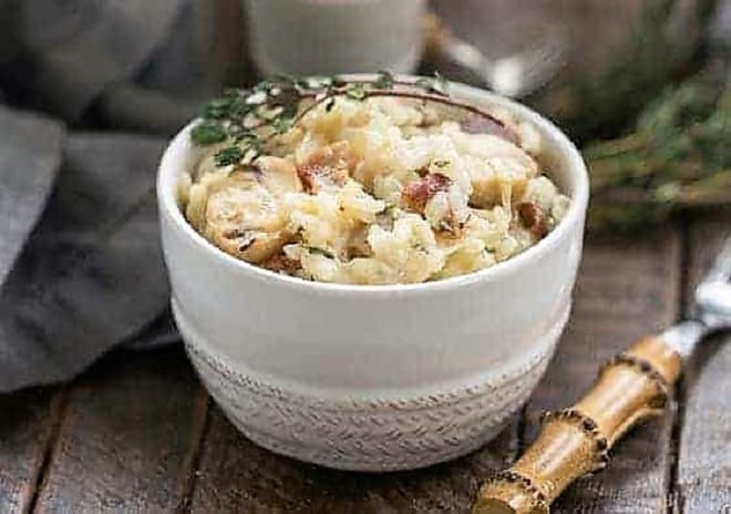 A bowl of bacon mushroom risotto in a white bowl