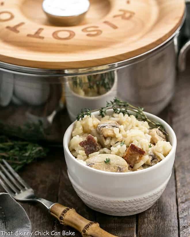 Bacon Mushroom Risotto with Caramelized Onions in a small white bowl with a garnish of thyme