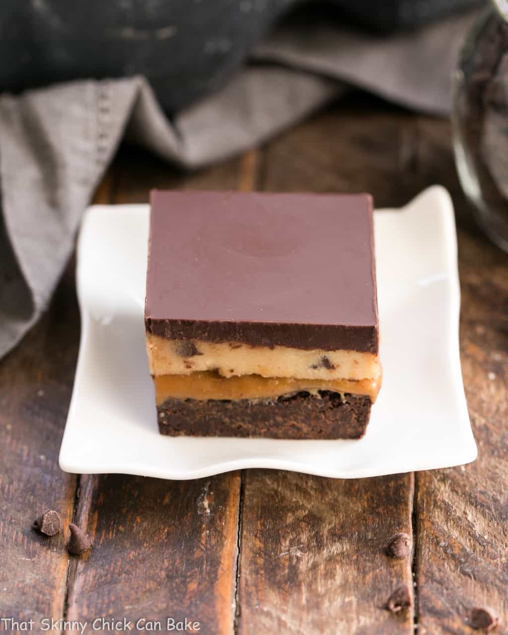 Cookie Dough Billionaire Bars on a small, wavy white plate.