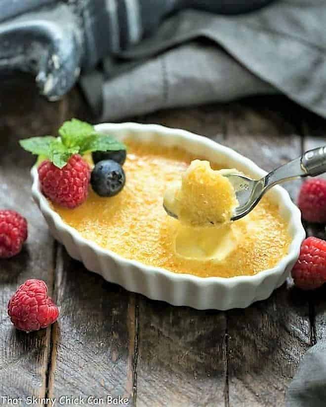 White Chocolate Crème Brûlée in a white ramekin with a spoon.