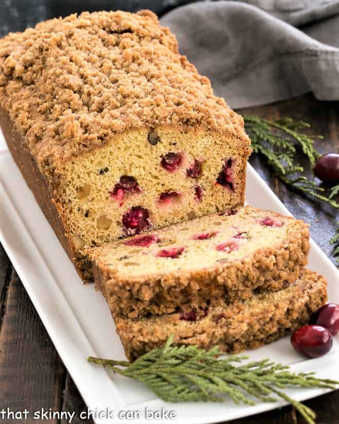 Streusel Topped Cranberry Orange Walnut Bread slices on a white platter.