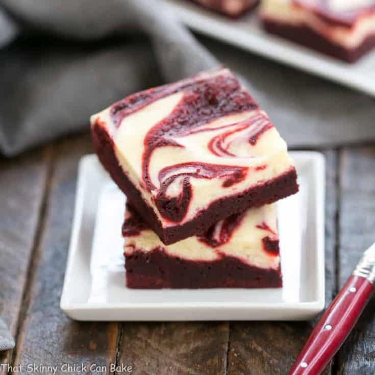 red velvet cheesecake brownies on a square white dessert plate