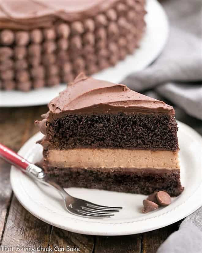 a slice of chocolate layer cake with chocolate cheesecake between the layers.