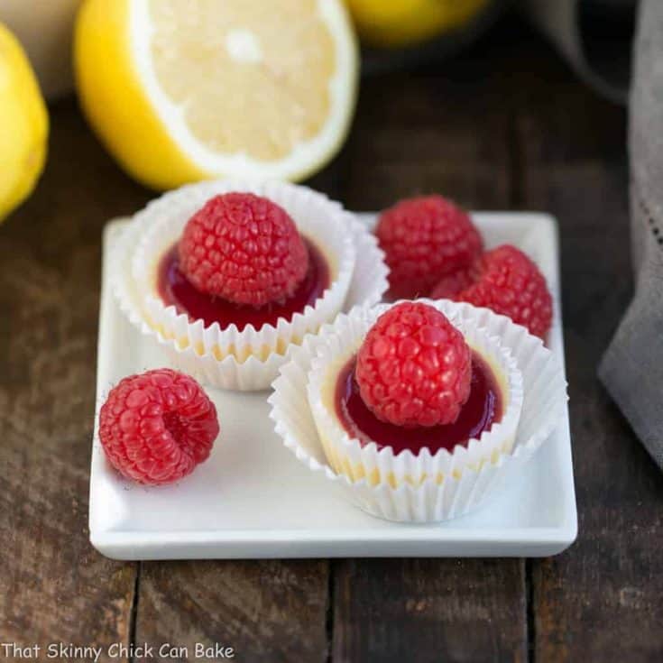 Raspberry Topped Mini Cheesecakes | Creamy mini cheesecakes topped with raspberry sauce and a plump ripe raspberry!