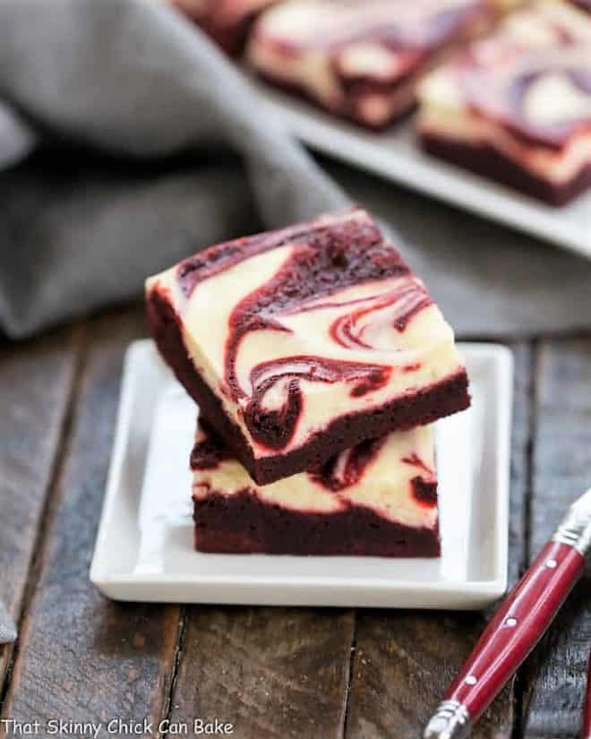 red velvet cheesecake brownies on a square white dessert plate