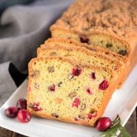 Streusel Topped Cranberry Orange Walnut Bread slices on a white platter