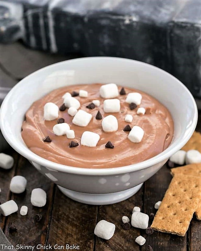 Easy S'mores Dessert Dip in a white bowl topped with mini marshmallows and chocolate chips.