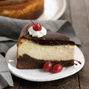 Hot Fudge Brownie Cheesecake featured image on a white plate with cherries