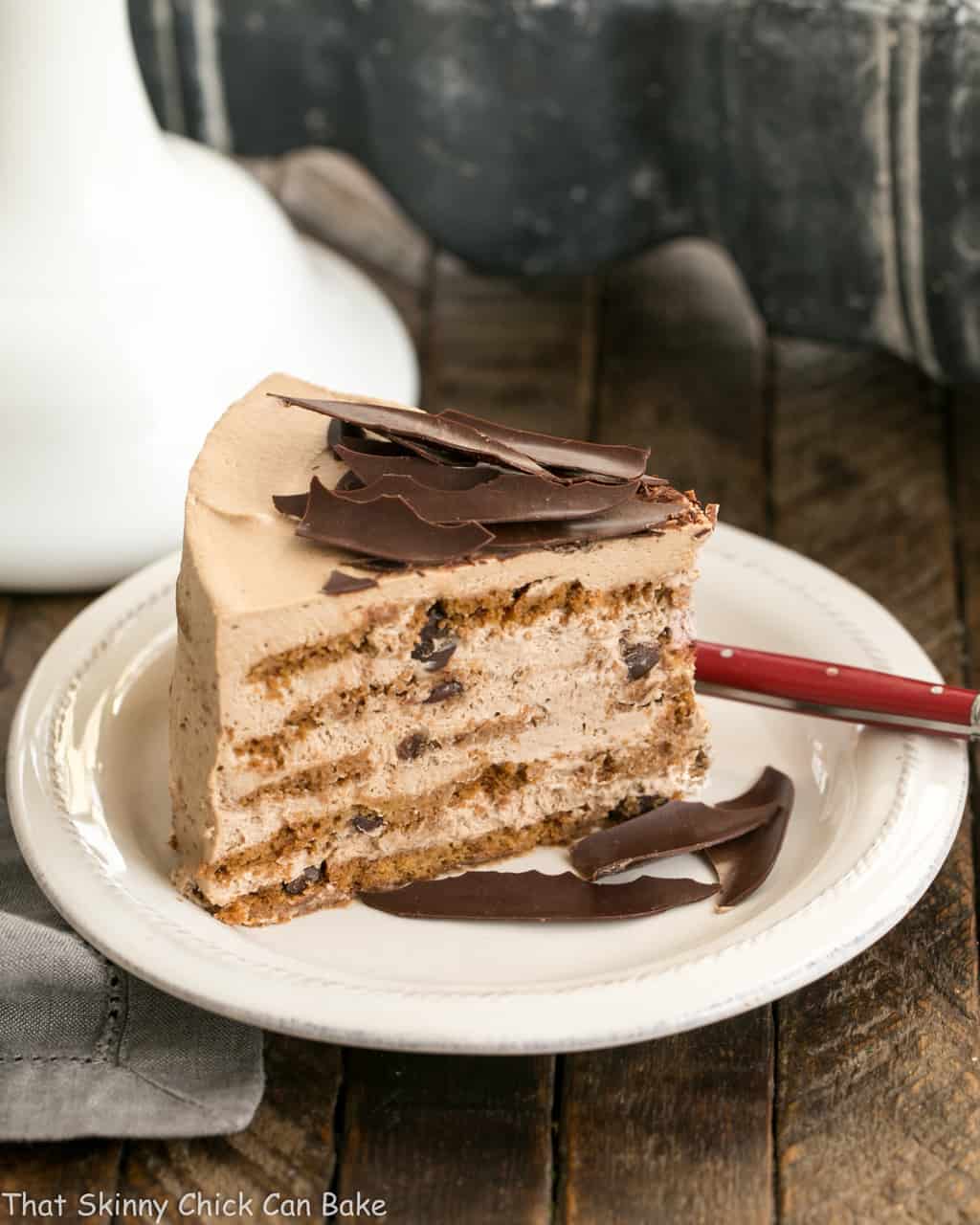 Mocha Chocolate Chip Cookie Icebox Cake slice on a white plate with chocolate shards.