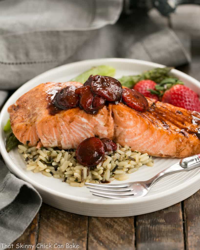 Strawberry Glazed Salmon on a white dinner plate with rice and fresh strawberries