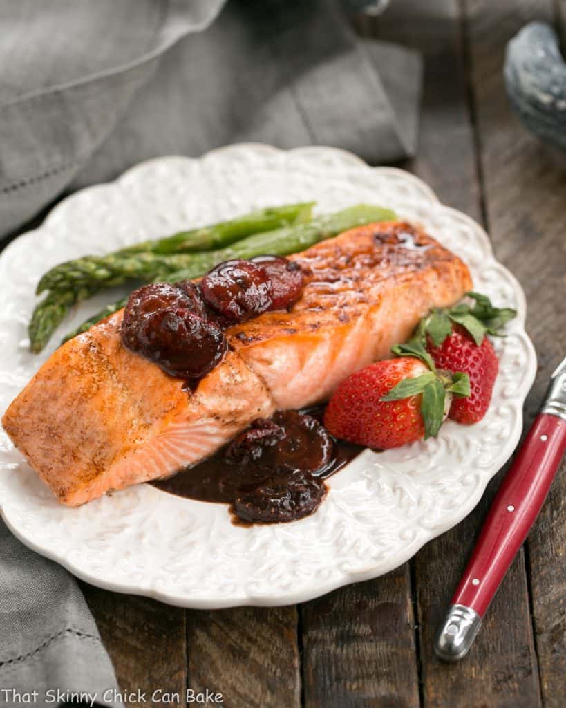 Strawberry Glazed Salmon on a dinner plate with asparagus and fresh strawberries
