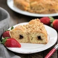 Slice of Streusel Coffee Cake Recipe on a white plate with strawberries